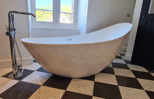 Baignoire îlot et sa robinetterie sur pied