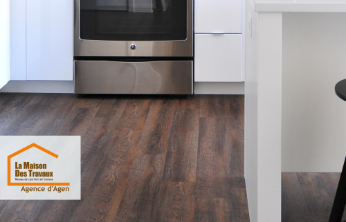 Un sol en parquet stratifié imitation bois foncé posé dans une cuisine moderne à Agen, par La Maison Des Travaux. Élégance et durabilité au rendez-vous.