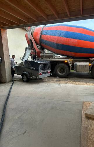 Coulage de la dalle béton lors de la rénovation de la grange dans ce chantier de transformation à Voiron.