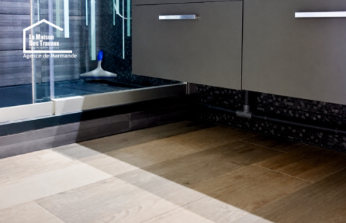 Détail de robinetterie et mosaïque noire dans une salle de bain rénovée à Casteljaloux.