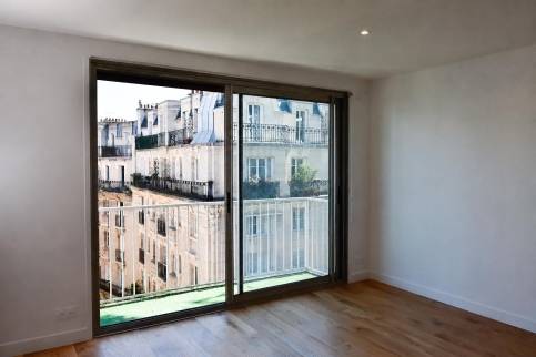 Séjour cuisine ouverte avec accès balcon, vue sur les toits de Paris