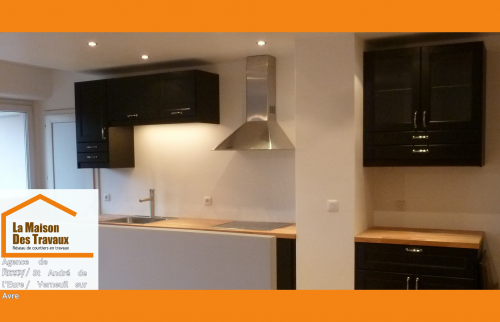 Élégance et fonctionnalité : cette cuisine noire et bois à Anet allie design sobre, rangement optimisé et électroménager intégré.