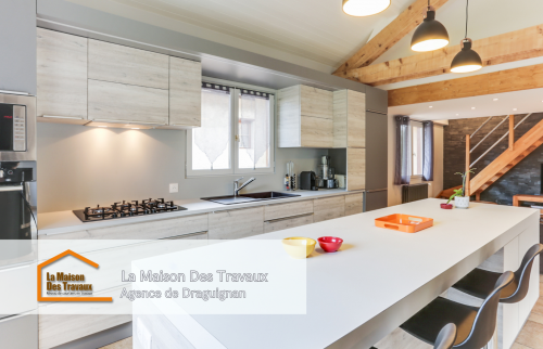 Les équipements encastrés, comme le four et le micro-ondes, rendent cette cuisine à la fois pratique et épurée. Le mélange des textures bois et gris donne un aspect contemporain et chaleureux à la pièce.