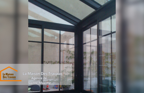 Vue de l’intérieur, où la véranda offre une luminosité accrue, avec une grande attention portée aux détails de l'installation des vitrages.  