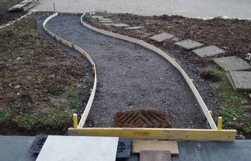 Réaménagement d’une entrée de maison avec allée en jardin en pente