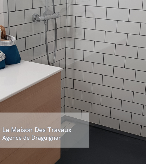 Vue de la salle de bain rénovée avec un carrelage métro élégant et une douche à l’italienne moderne.