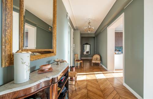 Rénovation à Saint-Cloud : Un miroir doré apporte une touche de luxe au couloir.