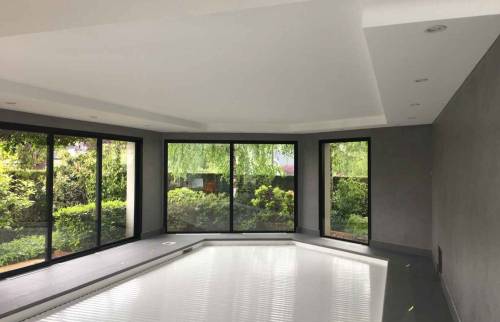 Piscine intérieure avec baies vitrées