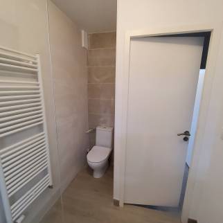 Espace WC dans la salle de bain, carrelage imitation bois et faïence ton pierre pour un espace chaleureux