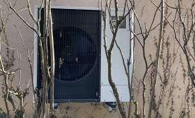 Installation extérieure, discrète, derrière la maison et camouflée par les arbustes