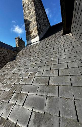 Diagnostic et reprise localisée de la couverture au niveau de la souche de cheminée, identifiée comme origine de l’infiltration d’eau.