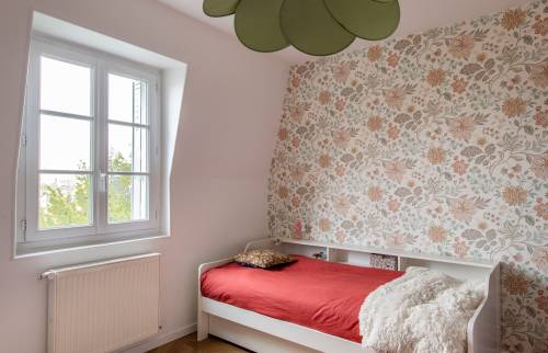 Lit simple et mur floral pour une chambre élégante à Paris 8e