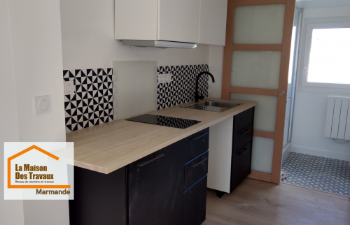 Rénovation complète d’une cuisine pour la location à Marmande : mobilier noir et blanc, plan de travail effet bois et aménagement optimisé par La Maison Des Travaux.