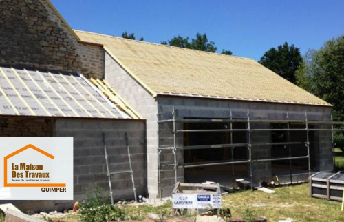 Étape intermédiaire d’une construction de garages proche de Quimper : élévation des murs, mise en place de la charpente et préparation de la couverture pour un chantier maîtrisé.