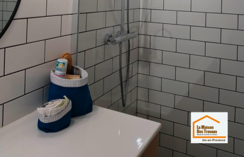 Douche à l’italienne avec receveur extra-plat noir, paroi vitrée et carrelage métro blanc lors d’une rénovation de salle de bain près d’Aix-en-Provence.