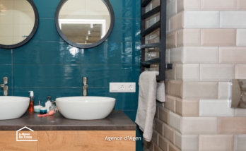 Rénovation de salle de bain à Agen avec double vasque, meuble en bois et carrelage bleu profond.