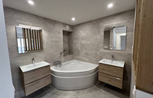 une salle de bain parentale avec baignoire centrale dans la suite rénovée - Le Chesnay