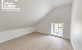 Pièce sous toiture avec plancher bois ancien et petite fenêtre dans une maison à Arzon