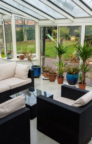 Véranda avec fauteuils et plantes décoratives 