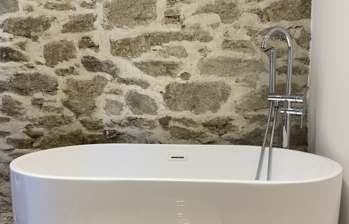 Mise en place de la baignoire à l'étage du loft accolée à la pierre de taille traitée sur Pleyben (29190)
