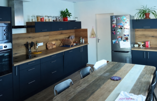 Avant/après d’une rénovation de cuisine à Sainte-Bazeille : l’ancienne pièce a laissé place à une cuisine contemporaine bleu nuit et bois, entièrement repensée.