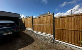 Mise en place d’une clôture rigide en bois sur muret existant, permettant de sécuriser le terrain tout en préservant l’esthétique extérieure.
