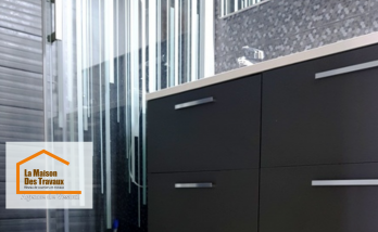 énovation élégante de salle de bain avec un meuble vasque suspendu au design moderne, une paroi de douche vitrée et un carrelage mosaïque noir hexagonal. 