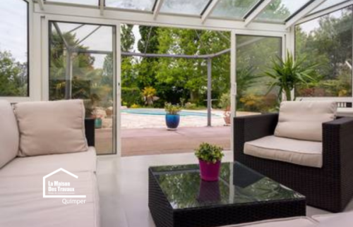 Véranda largement vitrée à Plomelin avec vue directe sur la piscine. Une réalisation pensée pour profiter davantage de la lumière et du jardin.