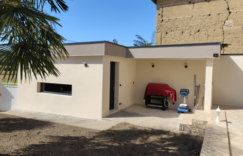 Garage et cuisine d’été réunis sous une toiture plate contemporaine à Saint-Cassien.