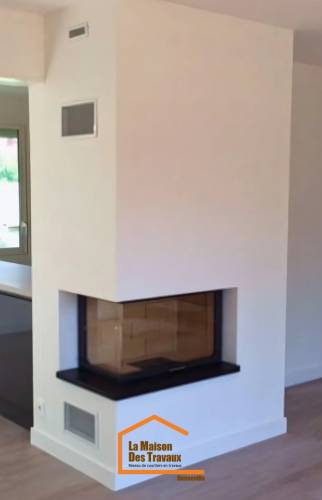 Cheminée encastrée d’angle à foyer fermé avec finition contemporaine blanche – installation réalisée en Haute-Savoie.