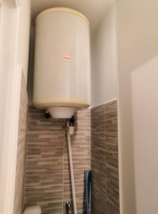 Placard dédié au chauffe-eau électrique et au lave linge dans la salle de bain