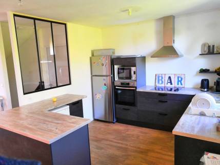 Vue d'ensemble de la cuisine effet béton noir et plan de travail bois