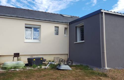 Vue arrière d’une maison à Six Fours les Plages après rénovation énergétique, avec façade claire isolée par l’extérieur et extension grise moderne.