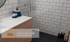 Vue de la salle de bain rénovée avec un carrelage métro élégant et une douche à l’italienne moderne.