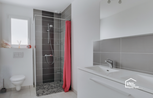 Rénovation d’une salle de bain à Aix-en-Provence avec douche ouverte, carrelage gris, meuble vasque et WC suspendu.