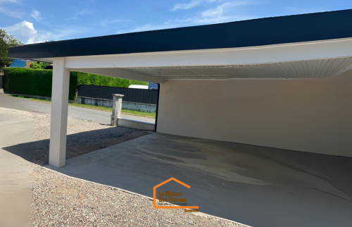 Carport double en Haute-Savoie avec toiture plate et espace de stationnement bétonné – réalisation contemporaine signée La Maison Des Travaux.
