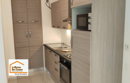 Aménagement d’une cuisine contemporaine avec colonnes de rangement et meubles toute hauteur permettant de maximiser l’espace disponible dans un appartement près de Venelles.