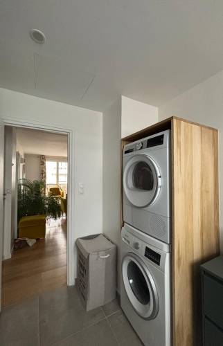 Espace buanderie avec lave-linge et sèche-linge dans une salle de bain moderne aux Batignolles