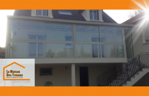 Véranda moderne à Bon-Encontre : une extension lumineuse parfaitement intégrée à la façade d’une maison traditionnelle.