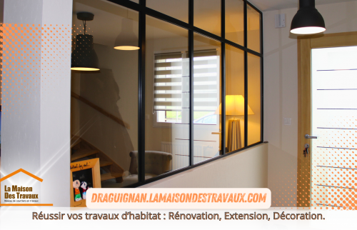 L’entrée est sublimée par une verrière noire qui offre une touche contemporaine et laisse circuler la lumière, contribuant à un intérieur chaleureux et accueillant.