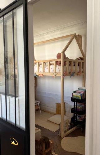 Chambre enfant avec lit cabane derrière verrière.