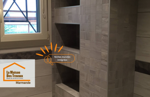 Niches murales intégrées, pensées pour allier praticité et esthétisme, habillées d’un carrelage effet pierre pour une touche haut de gamme.