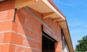 Résultat des travaux de charpente et de couverture à Labège, en Haute-Garonne, avec des débords de toiture en bois apparent.