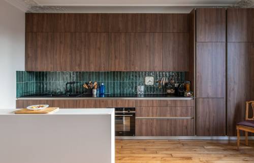 Cuisine design avec placards en bois foncé et appareils en noir à Paris 8e.