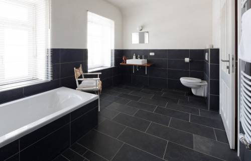 Salle de bain rénovée avec carrelage et baignoire assortie noir sur Alés 30100