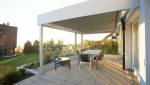 Coin repas dans un jardin sur une terrasse avec pergola 