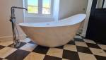 Baignoire îlot et sa robinetterie sur pied