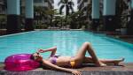 Une femme allongée sur un rebord de piscine 