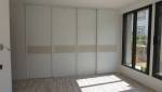 Pan de mur pièce dressing aménagé sur mesure façade coulissante mélaminé blanc et nouvelles baies vitrées coulissantes PVC noir - - Carquefou - 44470 - 