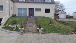 Réaménagement d’une entrée de maison avec allée en jardin en pente